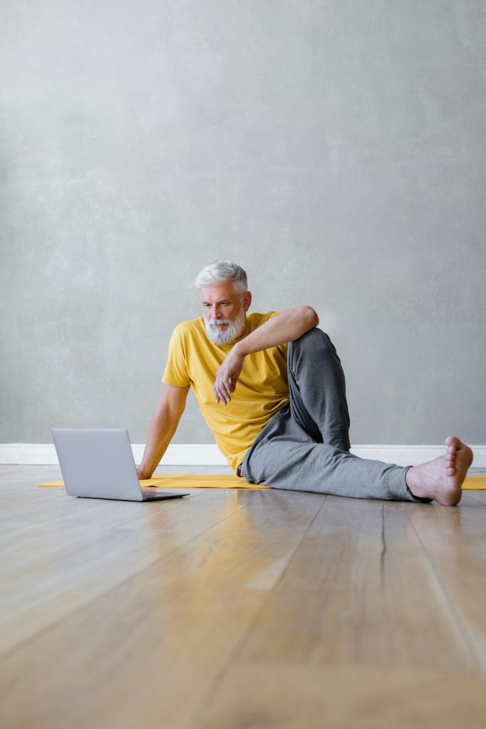 a man is sitting on the floor and watching a webinar on a sports website