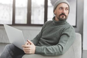 Professional marketing expert browses information on internet websites, uses laptop computer and wir